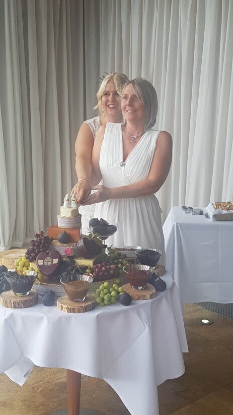 Bride and Bride cutting wedding cake (cheese cake) at Craig y Nos Castle 