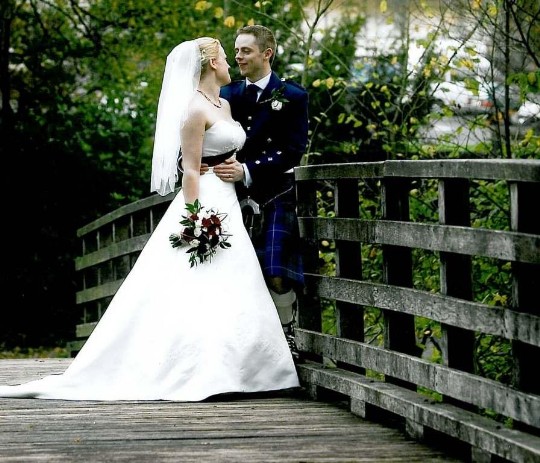 Bridal Couple on wooden footbridge leading from lower garden to country park Ceremony Only Weddings Venue South Wales Craig y Nos Castle