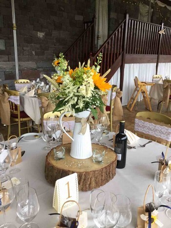 Log Centrepiece yellow flowers Wedding Tabe Wedding Table floral display on log on table