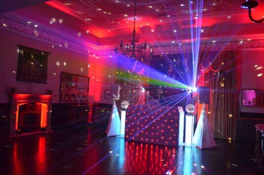 A party in the function room at Craig y Nos Castle, with Red Uplighting fEvening Evening Wedding Package south wales wedding venue