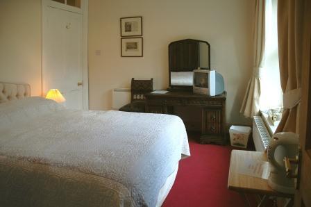 An old photo of En-suite Room AB23 - it now has a green carpet and and window blinds as well as curtains Wedding Venues South Wales - Craig y Nos Castle Accommodation Room AB23 bedroom