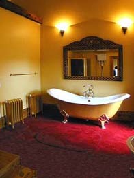 Bridal Suite roll top solid iron slipper bath on a raised carpeted platform Wedding Venues South Wales - Craig y Nos Castle Accommodation Room Bridal room slipper bath
