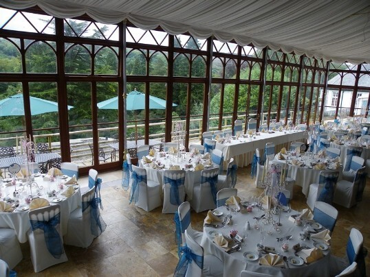 A popular pale blue ribbon and white chair cover wedding theme with cream napkins Craig y Nos Castle Wedding Venue Swansea Conservatary laid up in blue and white colours for wedding