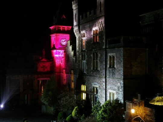 More contrasting colours as the light show cycles through different settings Craig y Nos Castle Wedding Venue Swansea Floodlit at Night in grey and purple alternating colours