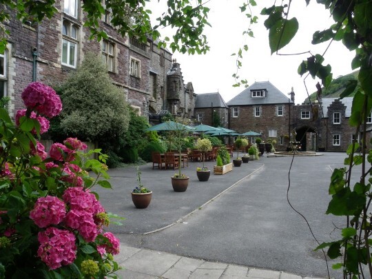Standing at the entrance to the theatre gardens, looking towards the atrium block (see arch on right) Craig y Nos Castle Wedding Venue South Wales Front Courtyard looking north to south