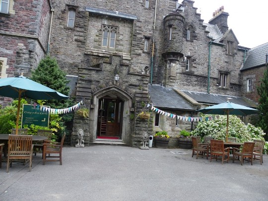 Front door and porch entrance to Craig y Nos Castle, bunting either side put in place by a wedding Craig y Nos Castle Wedding Venue Front entrance with bunting