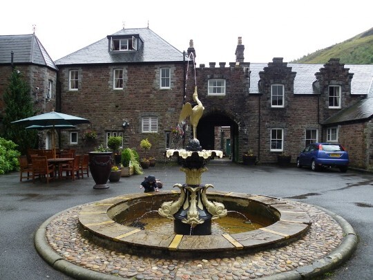 The Fountain at Craig y Nos, with atrium block and arch in background; atrium houses most of the en-suites Craig y Nos Castle Wedding Venue Wales Front Courtyard, Fountain and Atrium en-suites