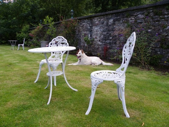 Craig y Nos Castle heatre Gardens, flat lawned area, walled garden, white table and chairs