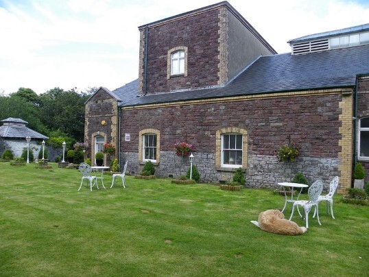 Flat lawn area, to one side of the theatre, the tall section is the theatre's stage area, housing the stage scenery Craig y Nos Castle Wedding Venue Swansea Theatre Gardens showing the side view of the opera house