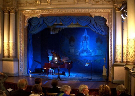Craig y Nos Castle's Adelina Patti theatre with grand piano on the stage, ready for a performance