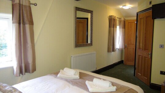 Looking from the head of the bed towards the bathroom door (right) of theatre loft en-suite room Wedding Venues Wales - Theatre Loft en-suite Bedroom