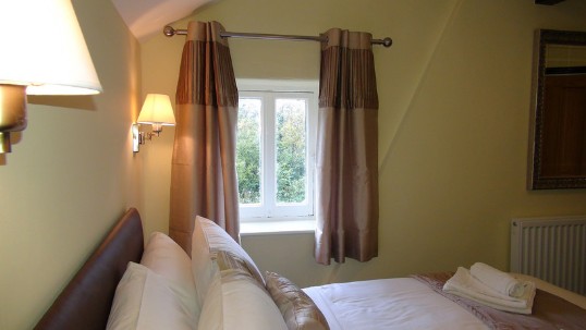 Looking towards one of two small windows in the theatre loft en-suite bedroom Wedding Venues Wales - Theatre Loft en-suite Bedroom