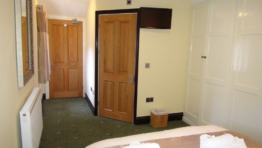 Theatre loft befroom, fitted white cupboards on right provide wardrobe space; this is a small cosy room Wedding Venues Wales - Theatre Loft en-suite Bedroom